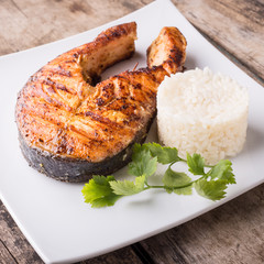 Roasted grill salmon steak with rice on white plate. Restaurant fish menu background