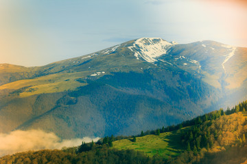 Landscape in the mountain:snowy tops and green valleys.