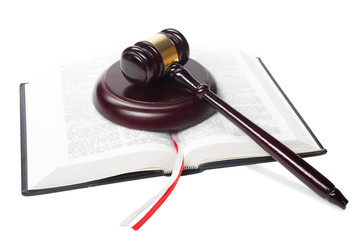 Law book with a wooden judges gavel on table in courtroom 