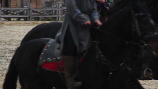 Men wearing ancient suits riding horses, medieval town atmosphere at museum