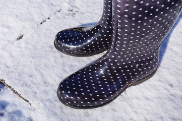 Black boots with polka dots walking in the snow