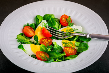 Fresh green salad with lamb's lettuce, cherry tomatoes and eggs