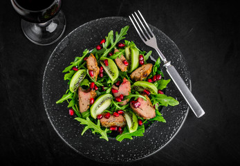 Salad appetizer with chicken liver, arugula, kiwi and pomegranate