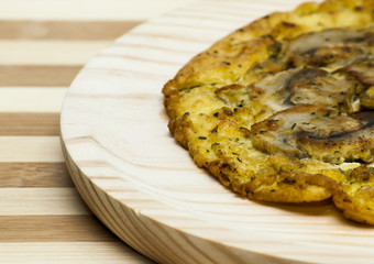 Omelette mushrooms on a wooden plate