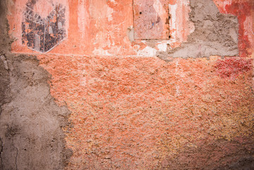 A distressed red ochre wall repaired with cement in Marrakesh
