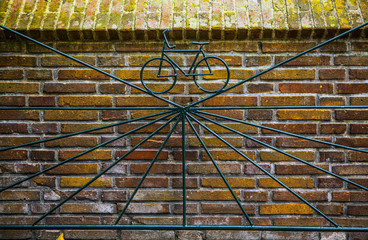Metal old gate with forged image of bicycle