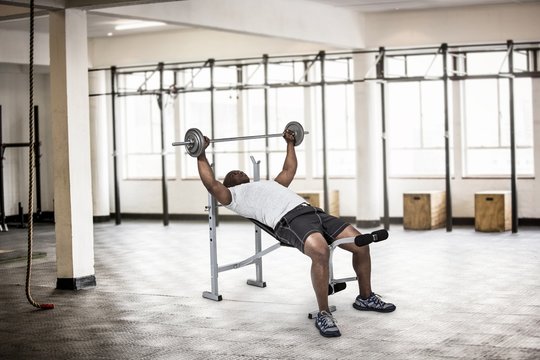 Composite image of fit man exercising with barbell 