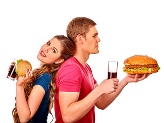 Young happy couple man and woman holding big hamburger and coca cola . Fastfood concept. Isolated.