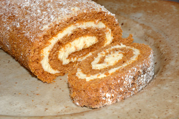 Pumpkin roll with cream cheese loaf and slices on plate