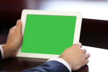 Businessman working with tablet at wooden table, closeup