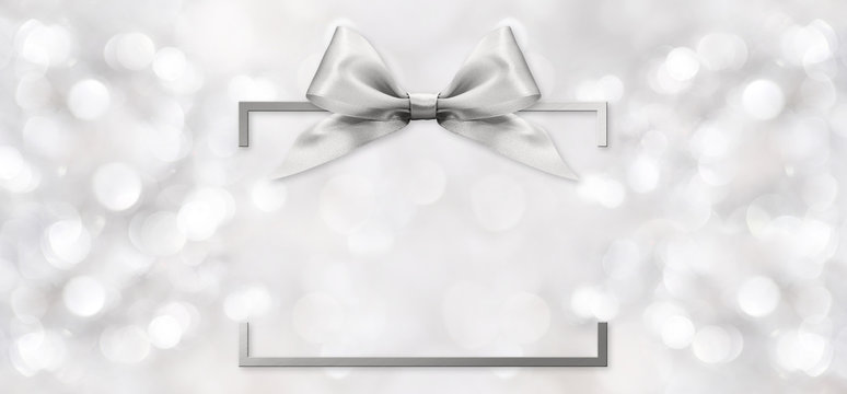 silver shiny ribbon bow on blurred background