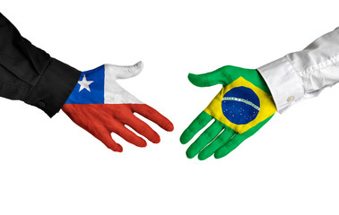 Chile and Brazil leaders shaking hands on a deal agreement