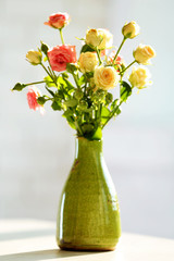 Fototapeta na wymiar Beautiful spring flowers in vase on window background