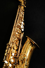 Beautiful golden saxophone on black background, close up