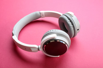 Wireless white and grey headphones on pink background