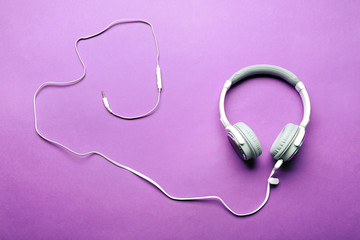 White and grey headphones on purple background