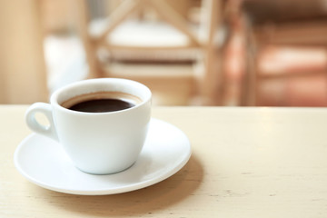 Cup of tasty coffee on cafe background