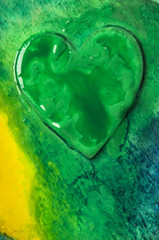Three-dimensional hand-painted green heart on colorful background. Gift for Valentine's Day.