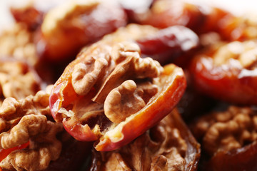Walnut and date fruit on wooden table, close-up