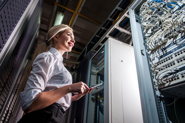 Young engineer businesswoman in network server room