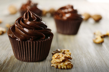 Chocolate cupcakes with nuts on wooden table