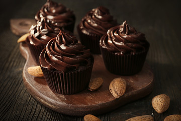 Chocolate cupcakes with nuts on cutting board