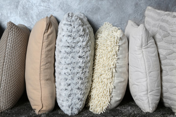 Few pillows on grey wall background