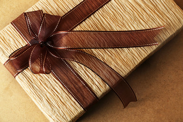 Beautiful gift with bow on wooden background
