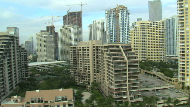 Flying around tall hotels and apartments in Miami.