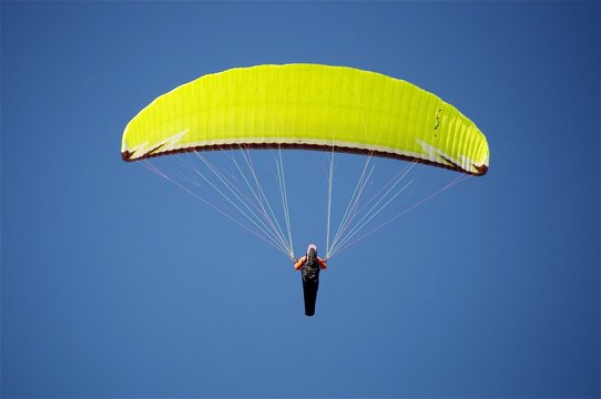 Gelber Paargleiter am Gleitschirm fliegen, am blauen Himmel