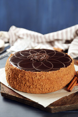 Tasty chocolate cake on color wooden background