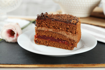 Sliced chocolate cake on plate, on wooden table  background