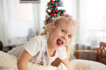 Fototapeta premium Photo of happy child girl with pillows before Christmas.