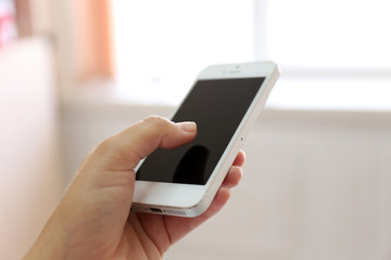 Woman holding smartphone indoors