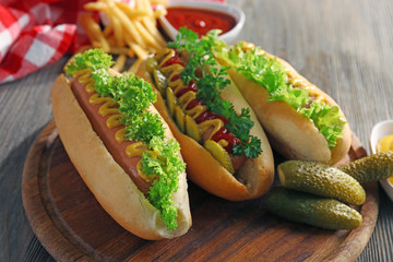 Tasty hot-dogs with vegetables on wooden table, close up