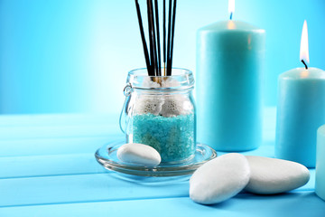 Spa composition of blue candles, stones and sea salt on blue background