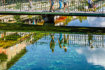 Reflecting people on a river in France