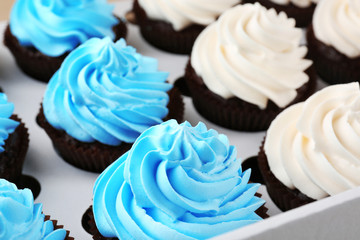 Tasty cupcakes in paper box, close up