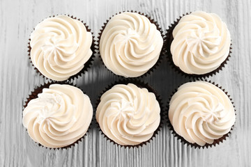 Tasty cupcakes on white wooden background, close up