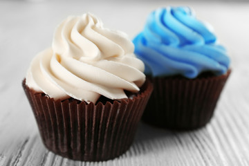 Fresh delicious cupcakes in a row on white wooden  background