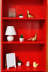 Red bookcase with white accessories, close up