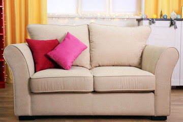Comfortable modern sofa with bright pillows in the room, close up