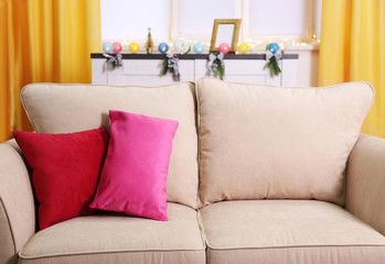 Comfortable modern sofa with bright pillows in the room, close up