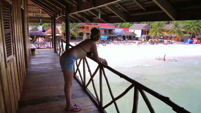 inviting tourist girl at bungalow with beach view