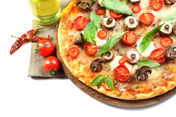 Tasty pizza and fresh vegetables on round wooden board, close up
