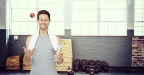 Fit young man with apple and water bottle