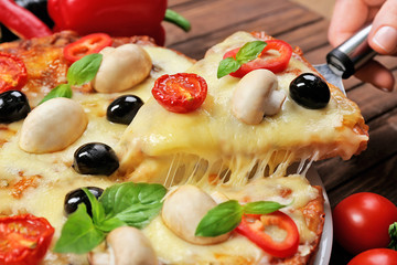 Delicious pizza and fresh vegetables on wooden background, close up