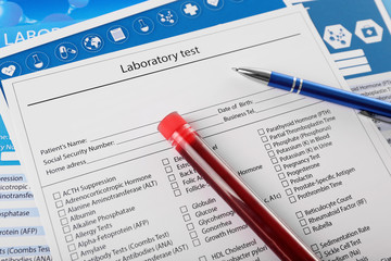 Obraz premium Blood in test tubes, pen and investigation form on the table, close-up