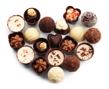 Heart-shaped collection of chocolate candies and sweets, isolated on white