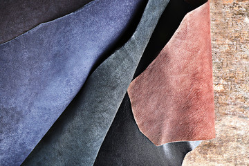 Ragged leather material wrong side, on the wooden table, close-up